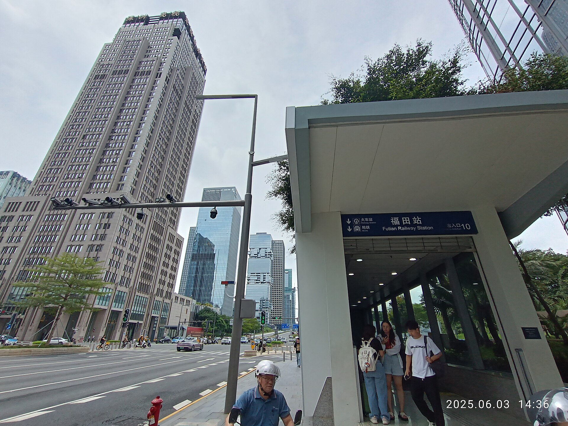 Futian Railway Station exit and entrance sign beside Shenzhen office towers